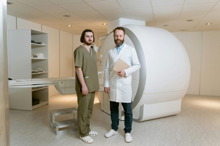 Two doctors standing beside an MRI scanner in a modern medical facility.